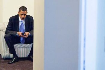 President Obama seated on couch with flip phone President Obama seated on couch with flip phone