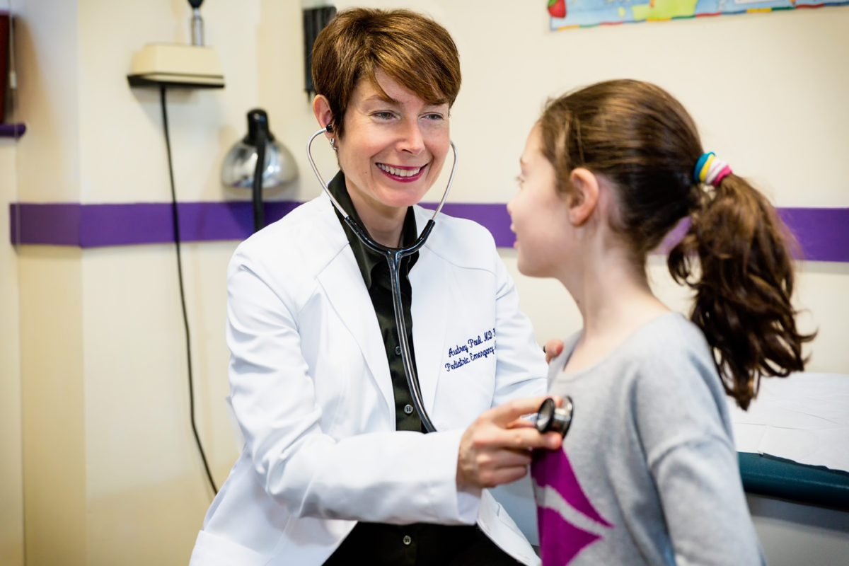 Photo shoot with healthcare worker, a pediatrician treating her young patient