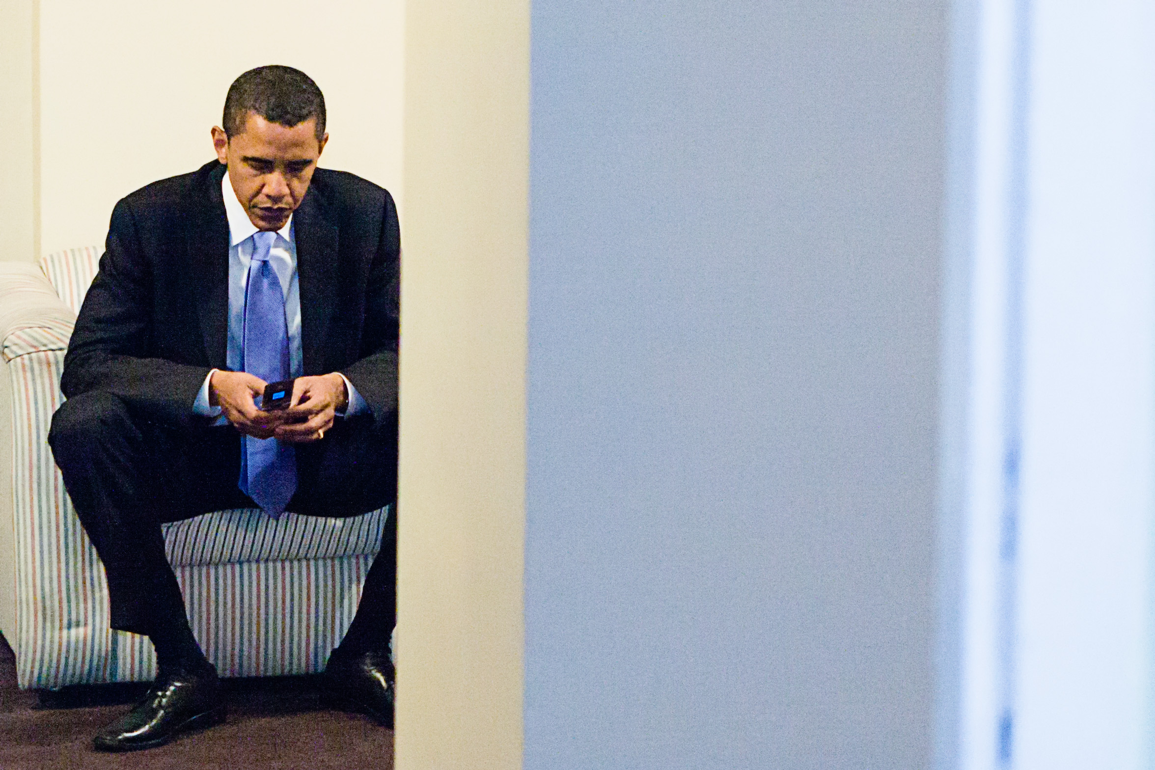 Obama sitting on couch with cell phone
